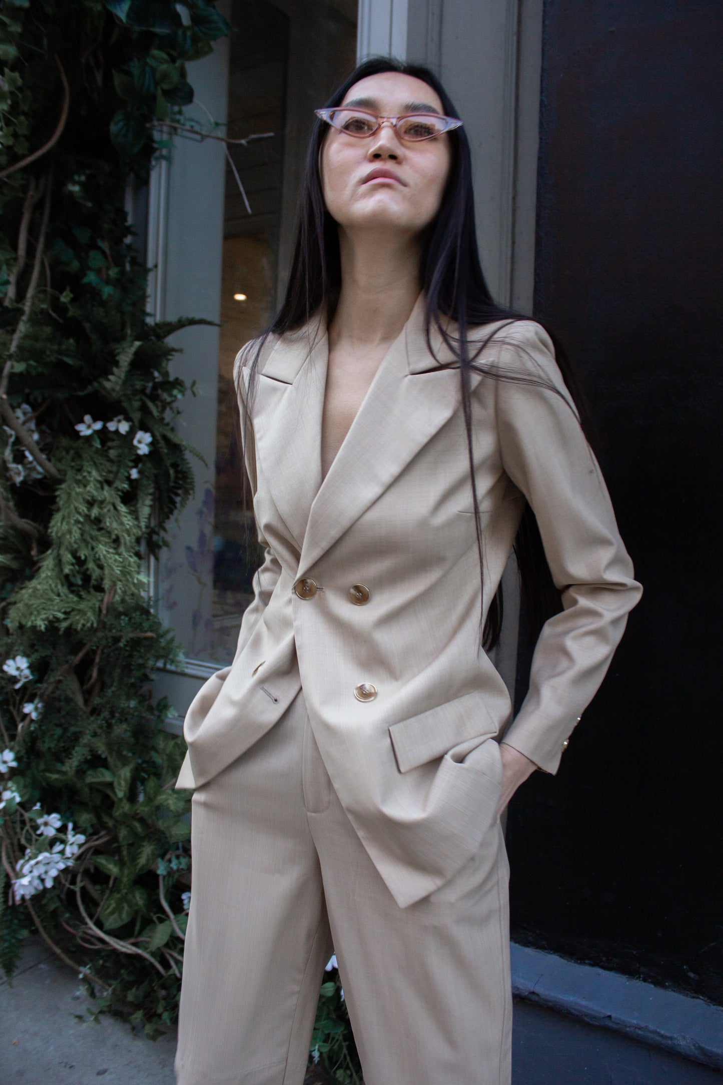 The Louise Blazer by Le Réussi® is a beige, double-breasted blazer featuring four buttons and two front pockets.