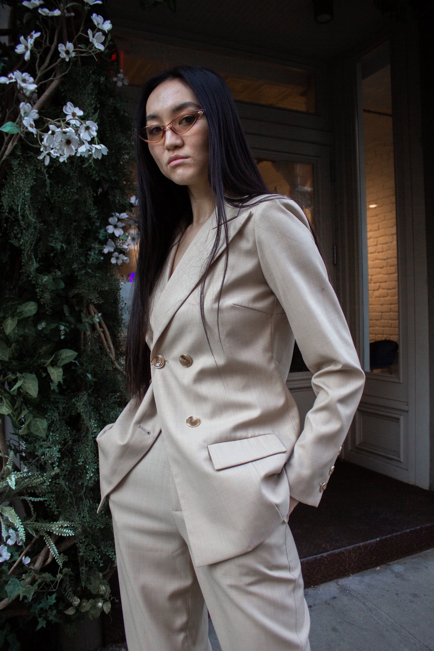 The Louise Blazer by Le Réussi® is a beige, double-breasted blazer featuring four buttons and two front pockets.
