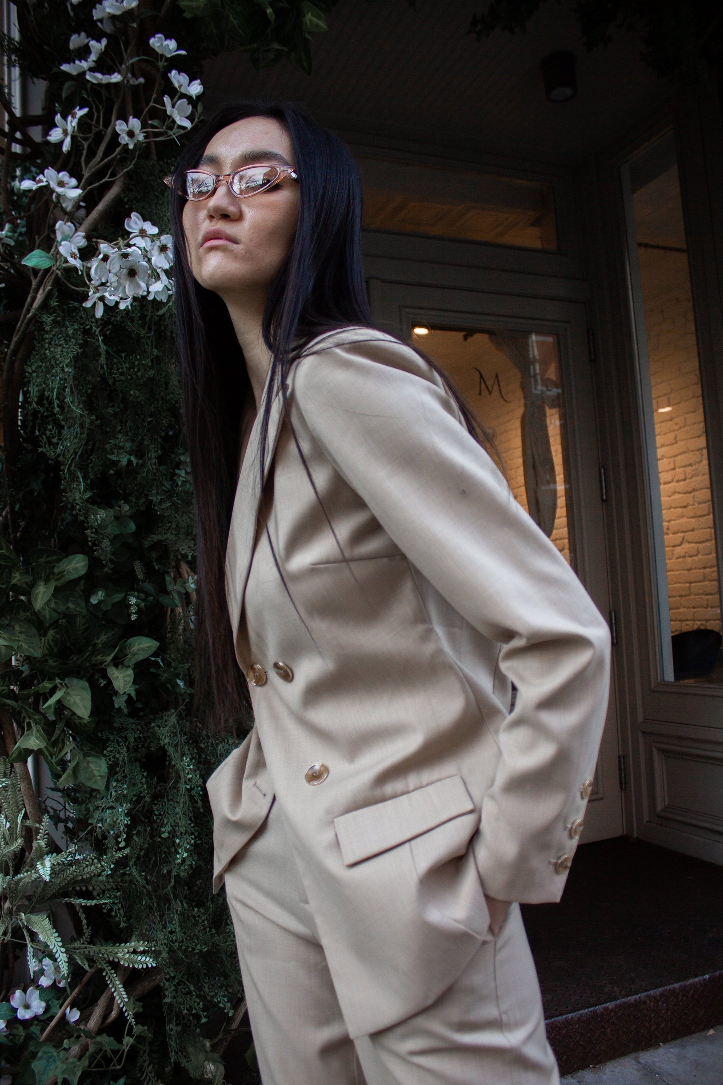 The Louise Blazer by Le Réussi® is a beige, double-breasted blazer featuring four buttons and two front pockets.
