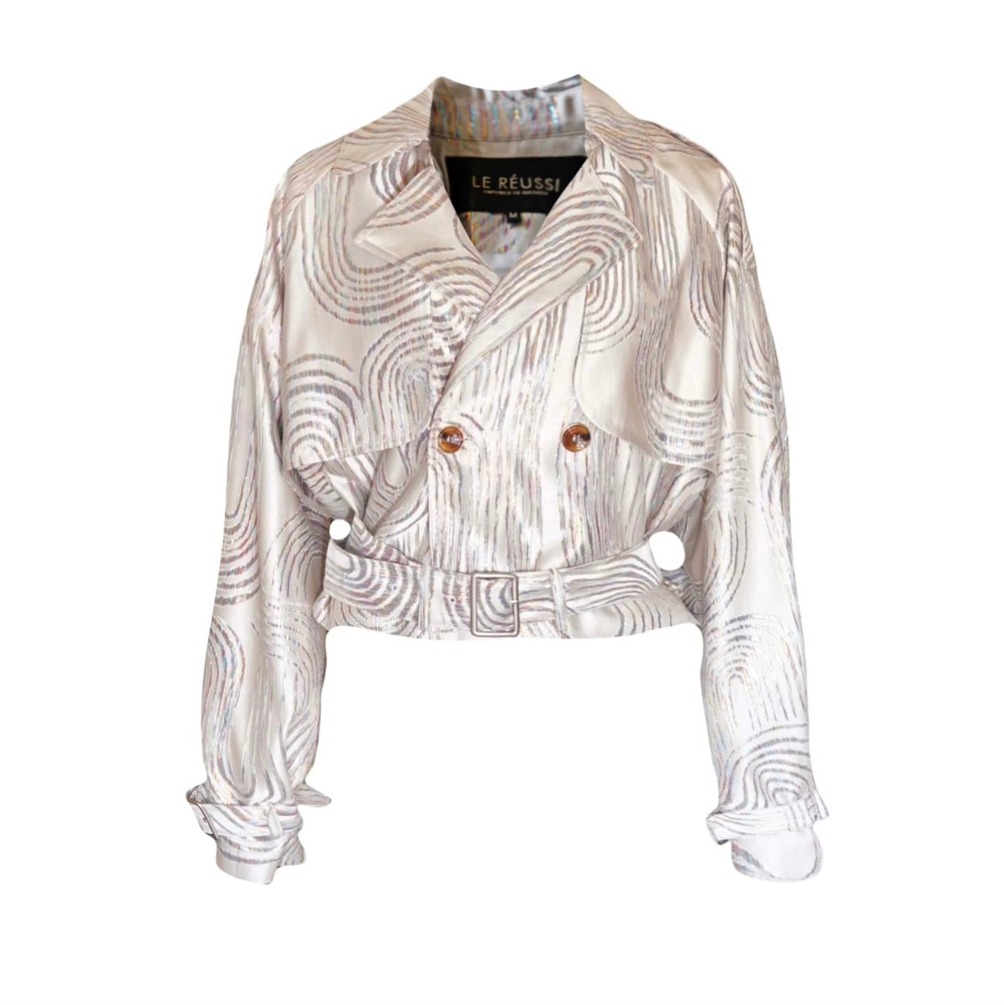 Jacqueline Beige Jacket by Le Réussi® features a white and silver pattern in a double-breasted design with a belt and buttoned cuffs, shown against a white background.