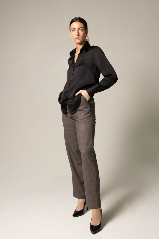A person in a black shirt and Le Réussi® Womens Straight Leg Pants stands confidently with hands in pockets, wearing black heels against a neutral background.
