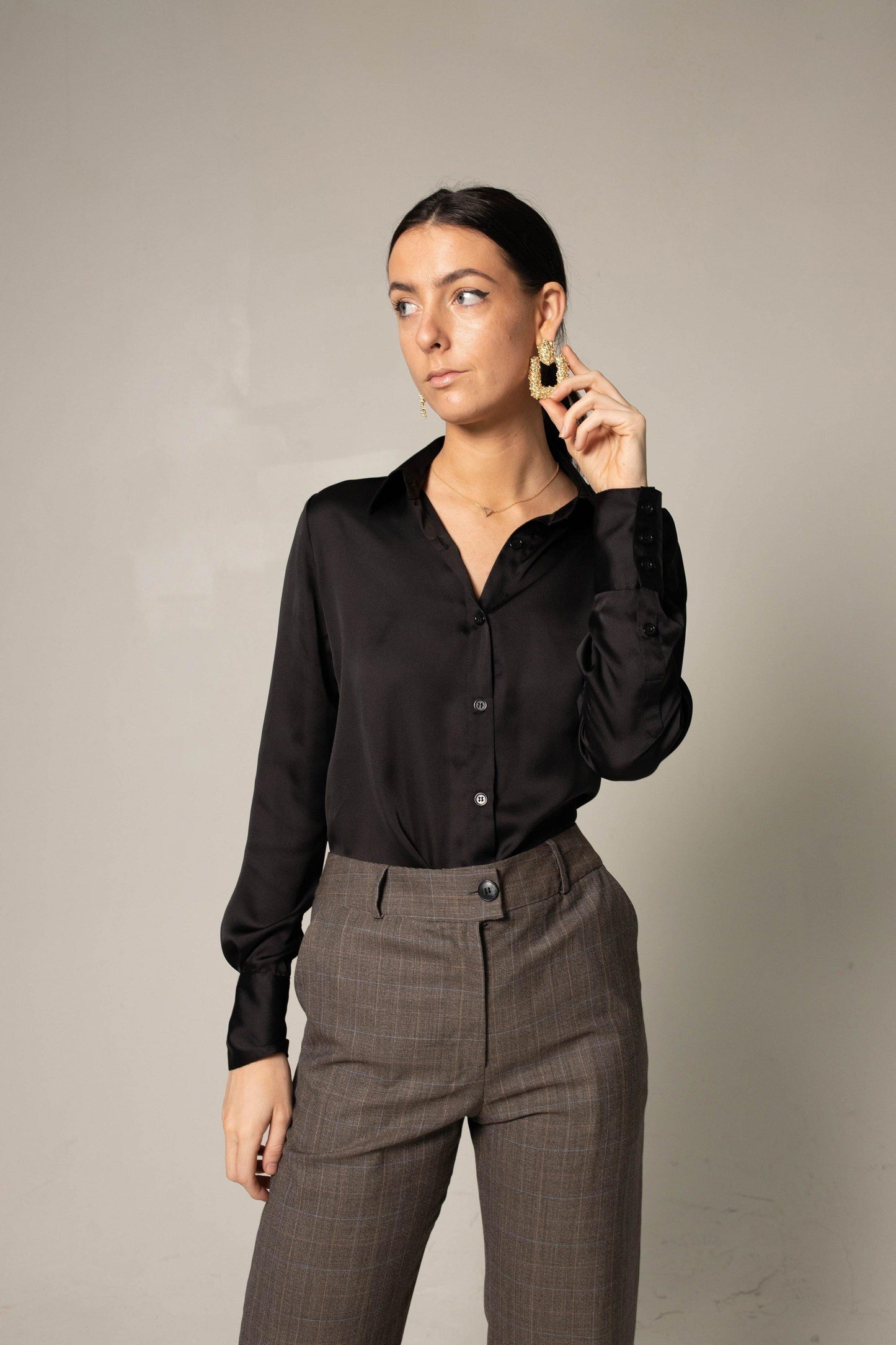 A person in a black shirt and Le Réussi® Womens Straight Leg Pants stands confidently with hands in pockets, wearing black heels against a neutral background.