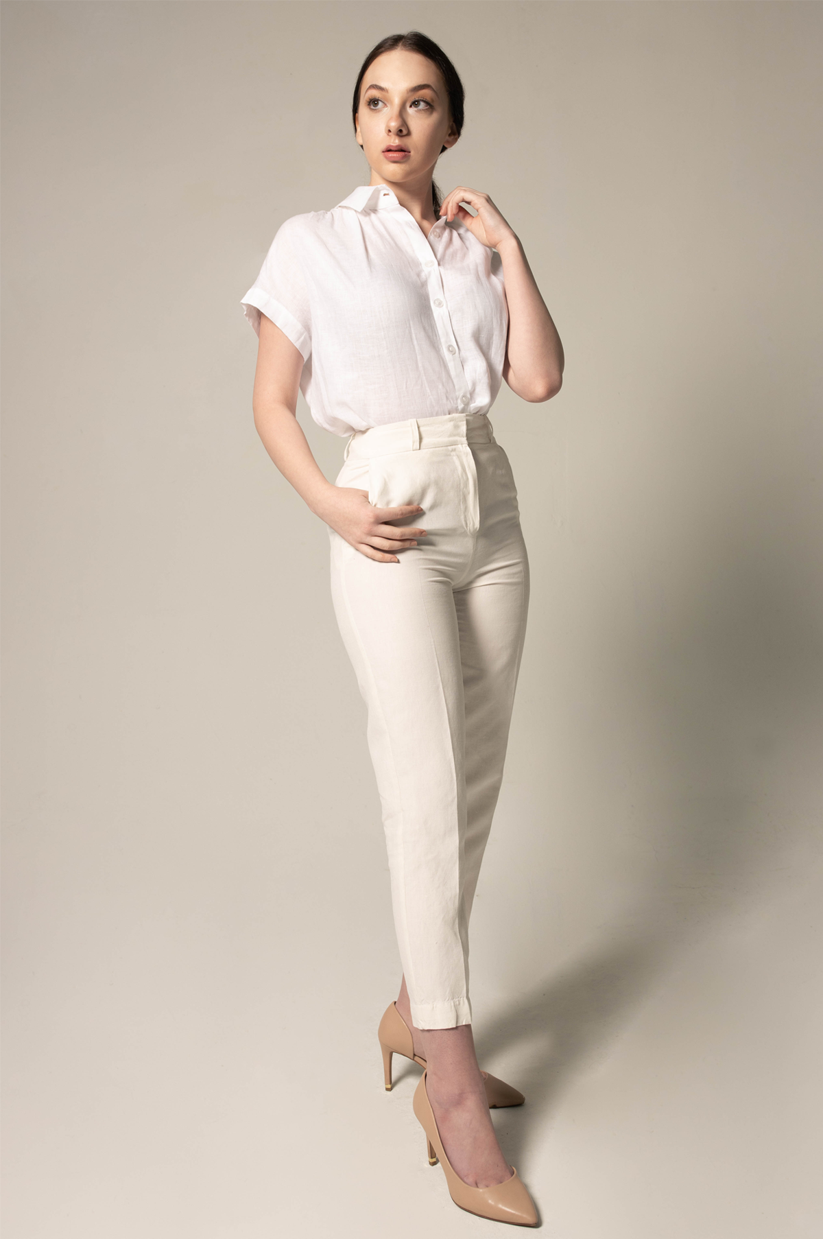 A person stands with crossed arms, wearing a Le Réussi® Womens Gather Collar Shirt in White and beige pants against a plain background.