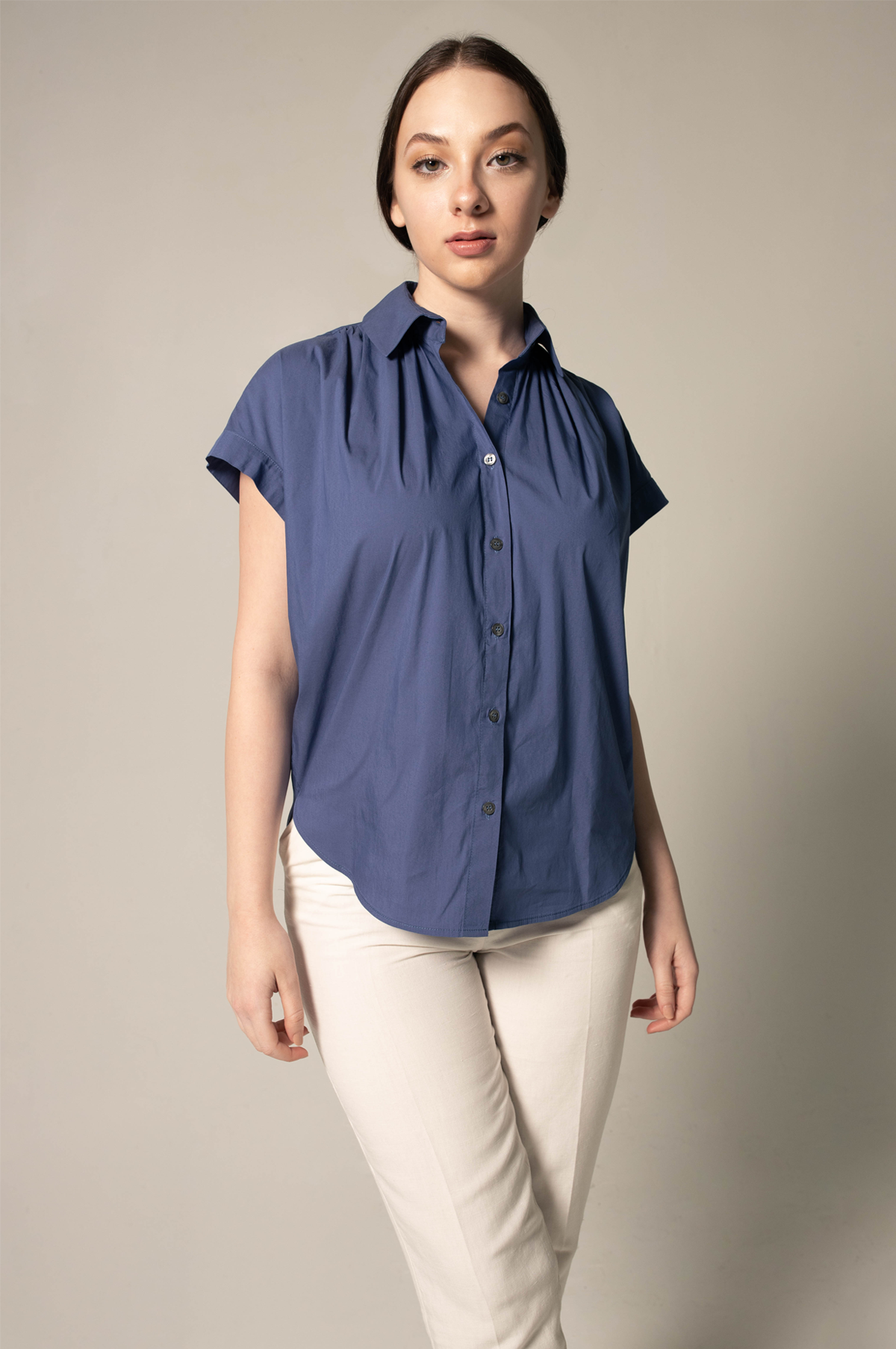 A person wearing Le Réussi® Womens Gather Collar Shirt in Navy and light pants stands against a plain background.
