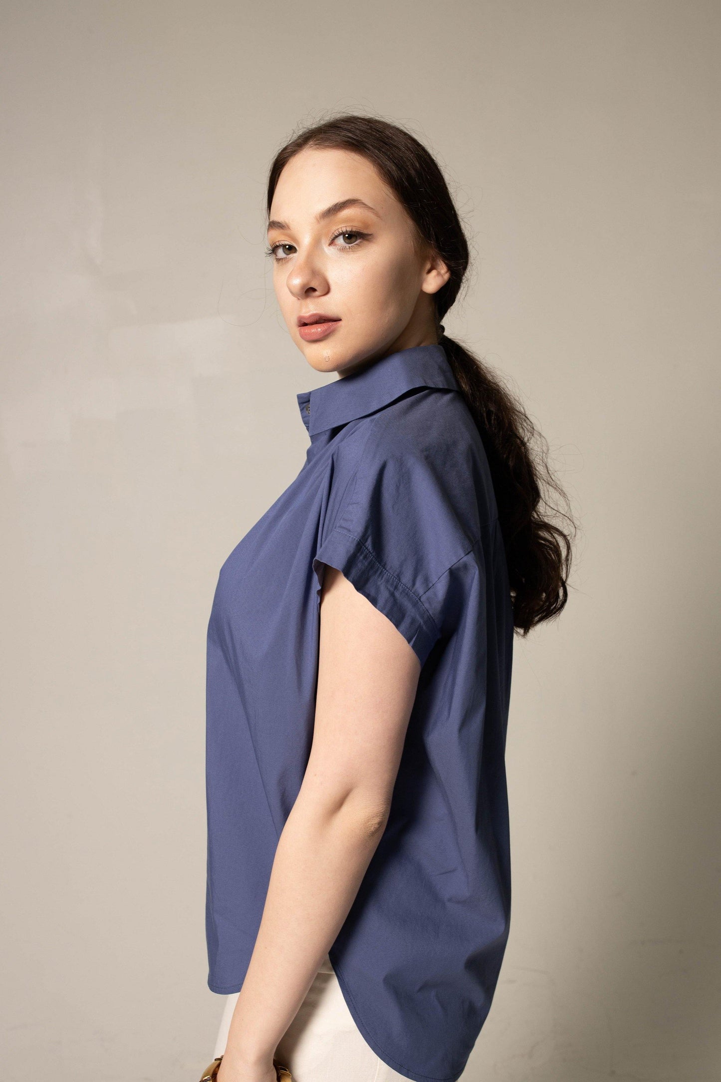 A person wearing Le Réussi® Womens Gather Collar Shirt in Navy and light pants stands against a plain background.