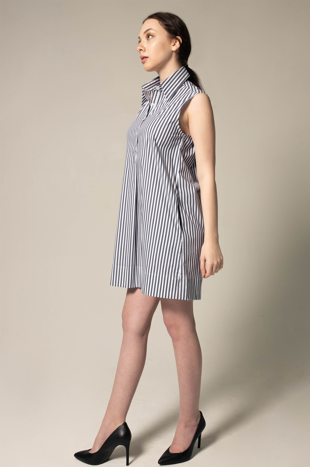 A model showcases the Italian Cotton Blue Stripe Sleeveless Dress by Le Réussi®, paired with black heels against a plain beige background.