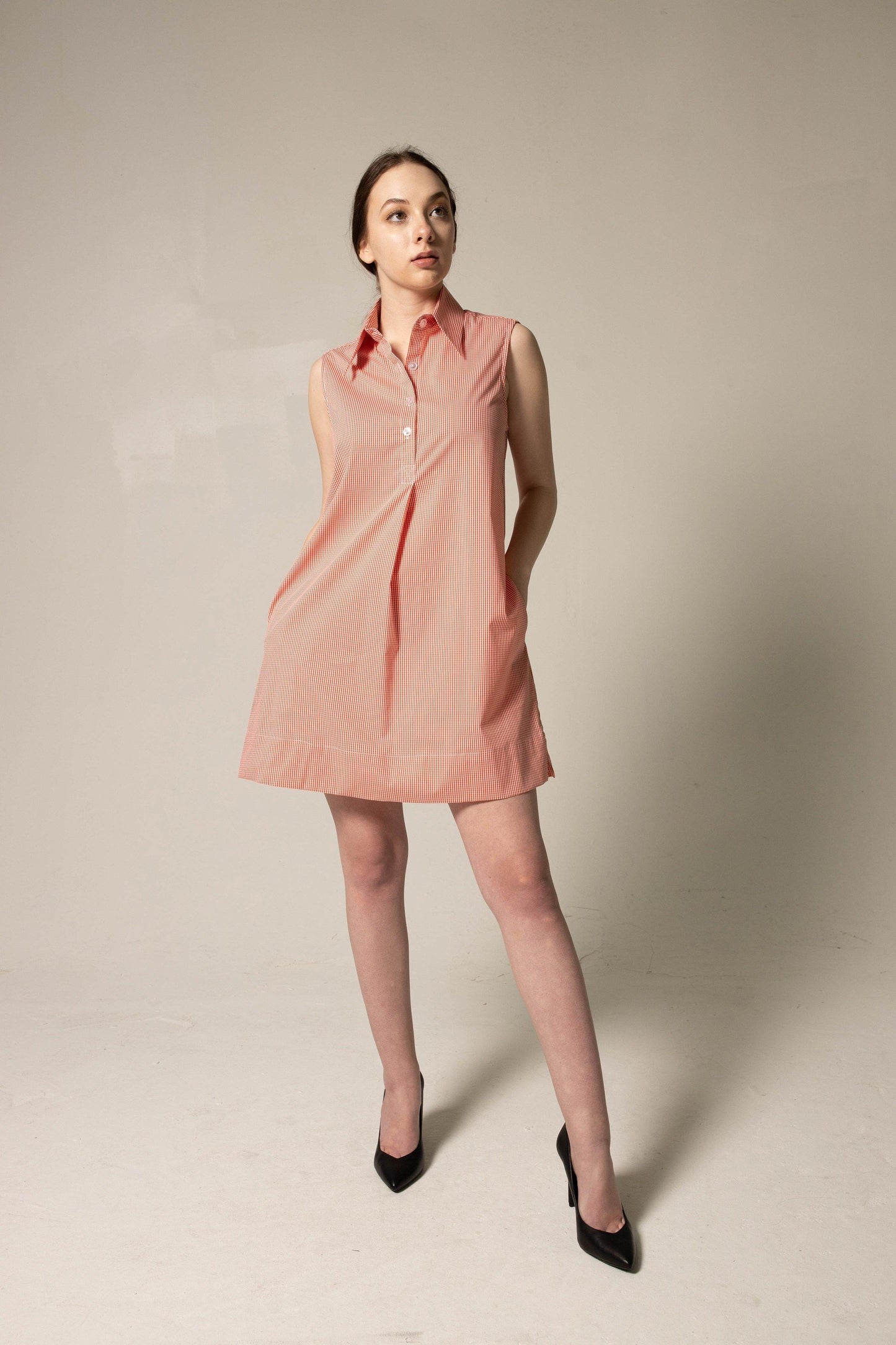 A person in a Le Réussi® Italian Cotton Red Stripe Sleeveless Dress and black heels stands against a plain background.