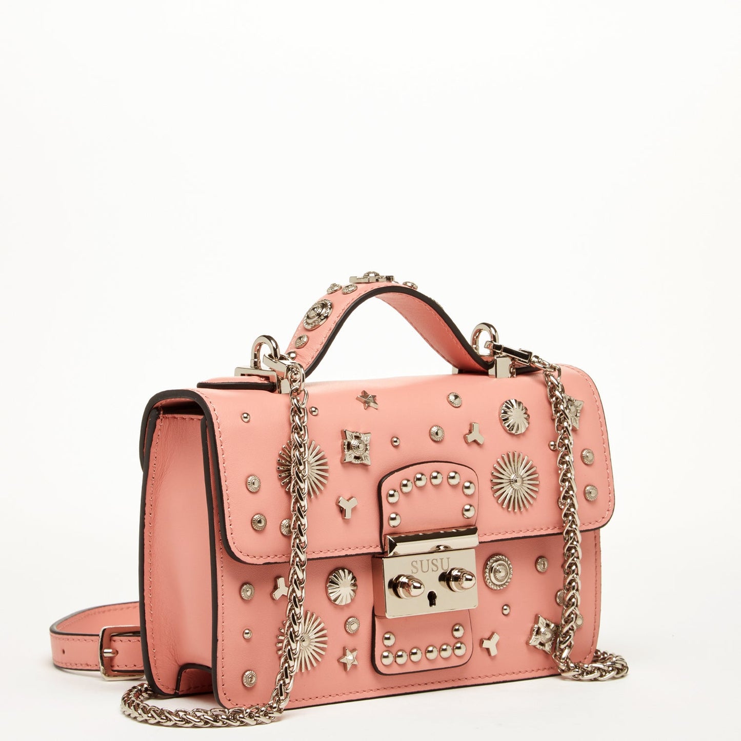 The Hollywood Leather Crossbody Bag Pale Pink by SUSU features metal studs, decorative patterns, a chain strap, and a buckle closure.