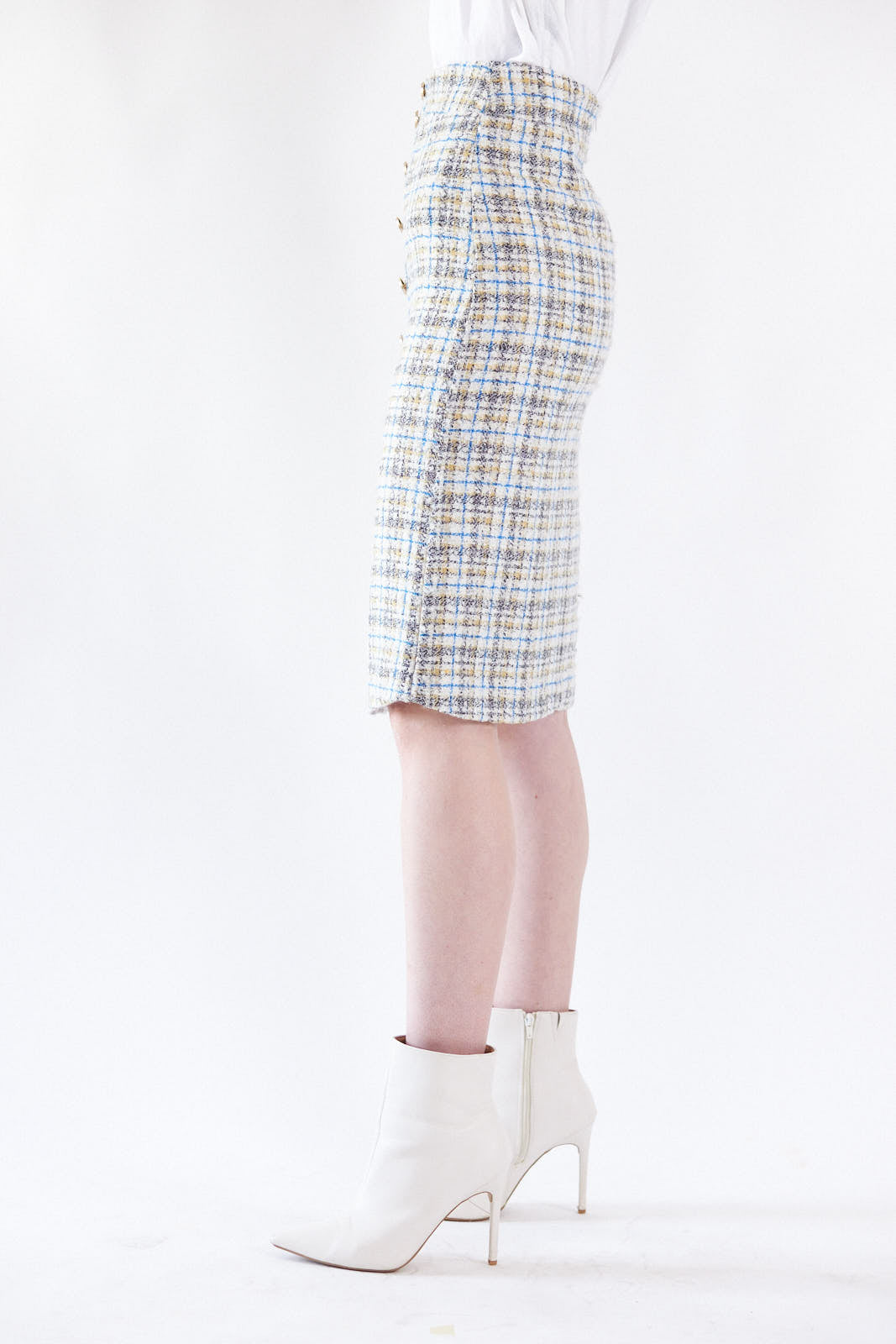 A person is wearing the Power Woman- Eye Catching Tweed Skirt by Le Réussi®, a high-waisted, button-down plaid skirt in blue, beige, and white, paired with a white blouse.