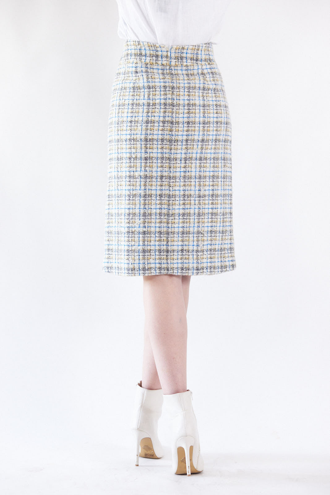 A person is wearing the Power Woman- Eye Catching Tweed Skirt by Le Réussi®, a high-waisted, button-down plaid skirt in blue, beige, and white, paired with a white blouse.