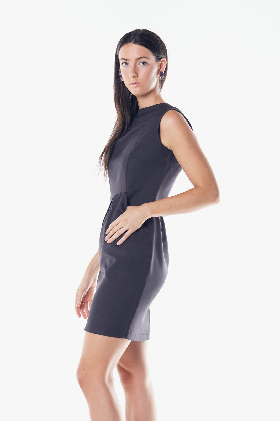 A model wearing Le Réussi®s Italian Wool Dress Pleated with Pockets in gray and knee-high boots strikes a pose with arms slightly extended and a plaid scarf elegantly draped around the neck.