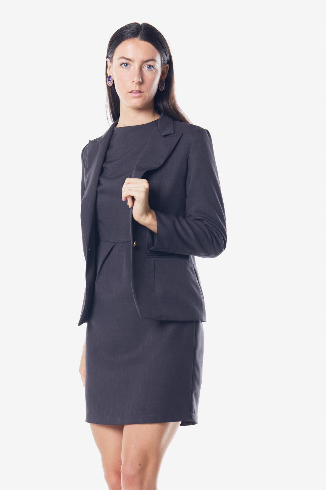 A model wearing Le Réussi®s Italian Wool Dress Pleated with Pockets in gray and knee-high boots strikes a pose with arms slightly extended and a plaid scarf elegantly draped around the neck.