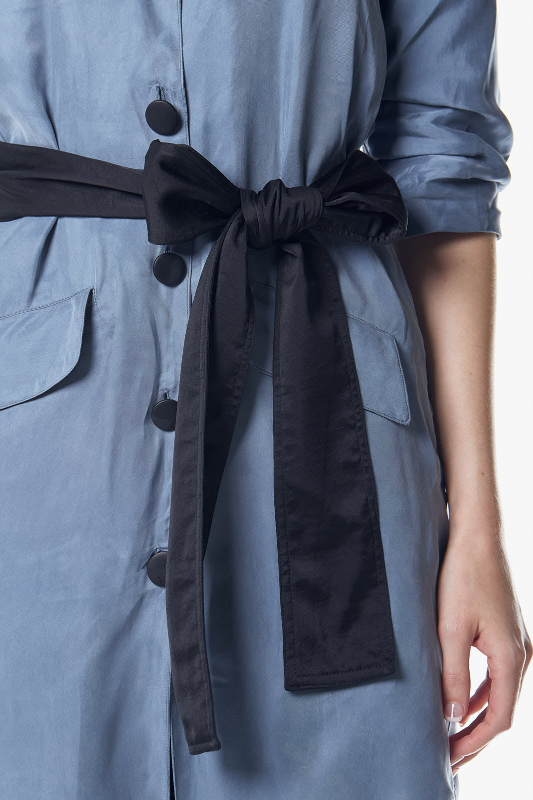 A person stands against a plain background, wearing the Cielo Blue Blazer Dress by Le Réussi®, accented with a black belt and paired with black ankle boots.