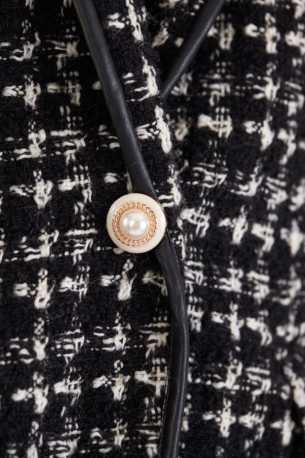 Close-up of Le Réussi®s Power Woman Black & White Tweed Checkers Jacket featuring decorative pearl buttons.
