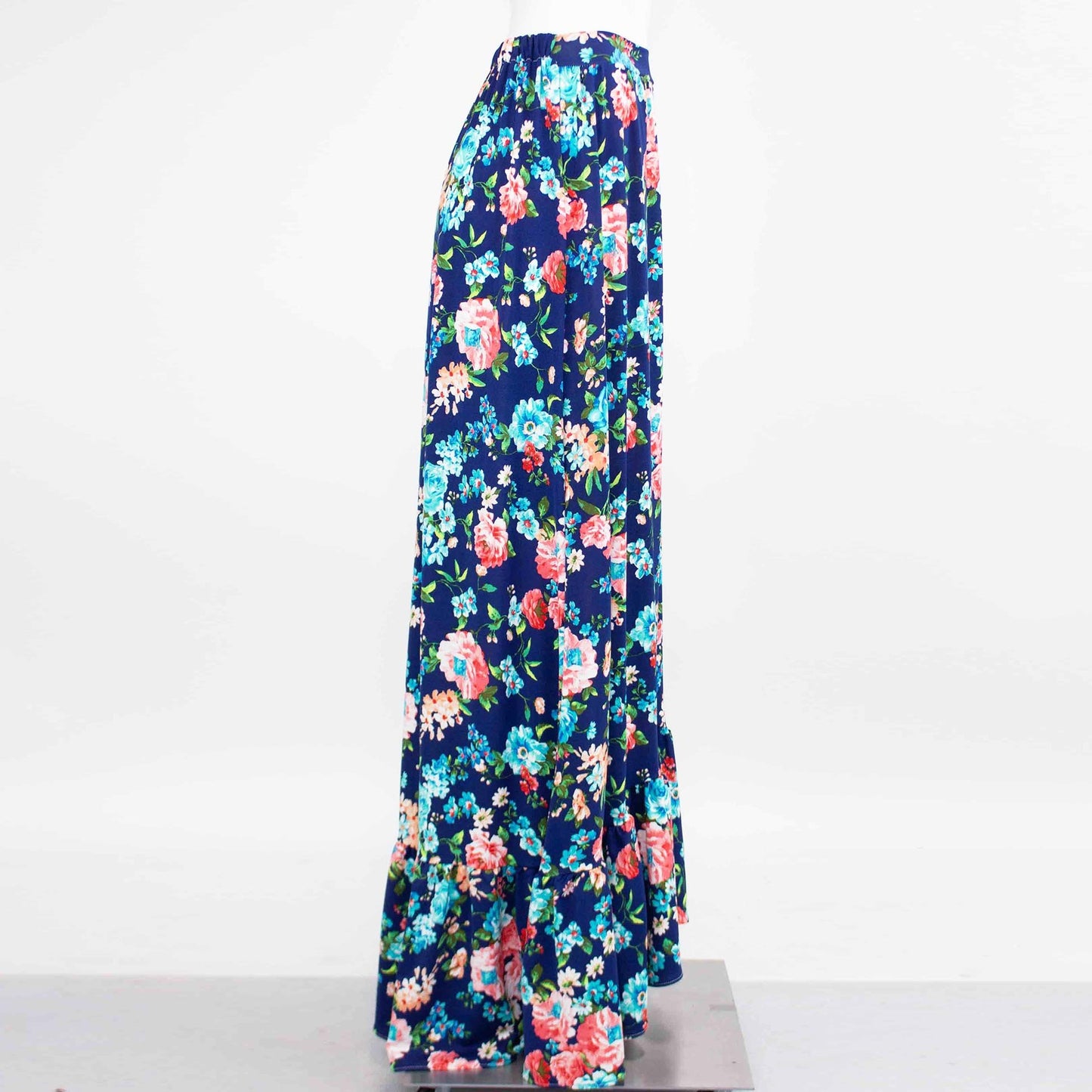 A Flared Bottom Flower Maxi Skirt by Stylespect, featuring a blue floral design and a ruffled hem, displayed on a mannequin.