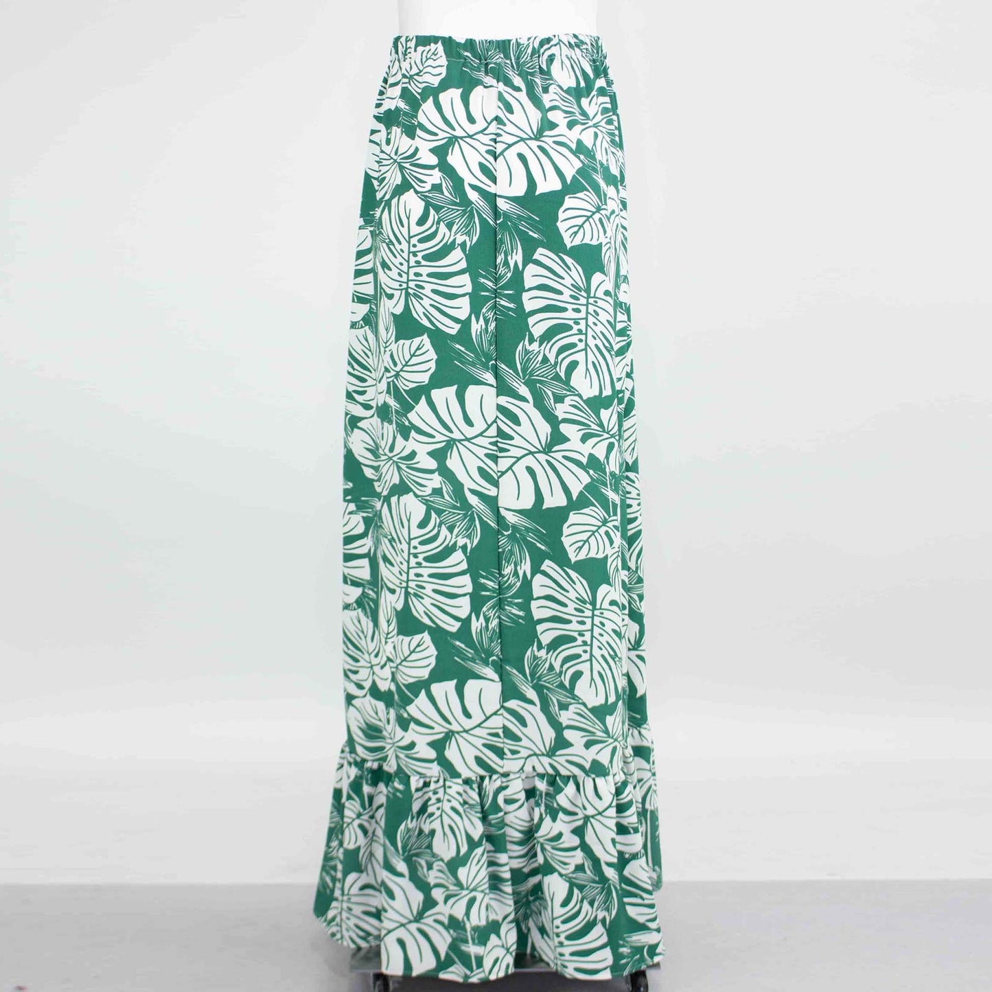 Stylespects Flared Bottom Leaf Maxi Skirt in green, featuring a white leafy pattern and ruffled hem, displayed against a plain background.