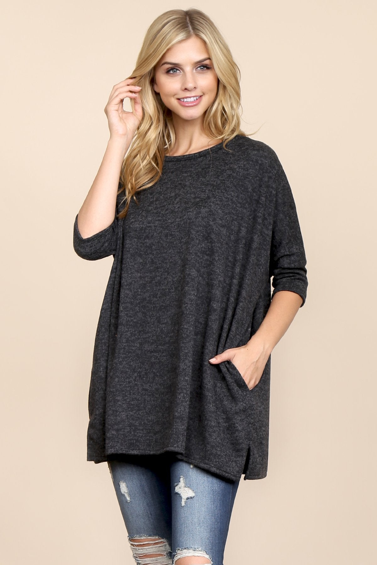 A woman stands against a beige background, wearing Riah Fashions Two Tone Hacci Oversized Dropped Shoulder Pocket Tunic in mustard, with hands in pockets and paired with ripped jeans.