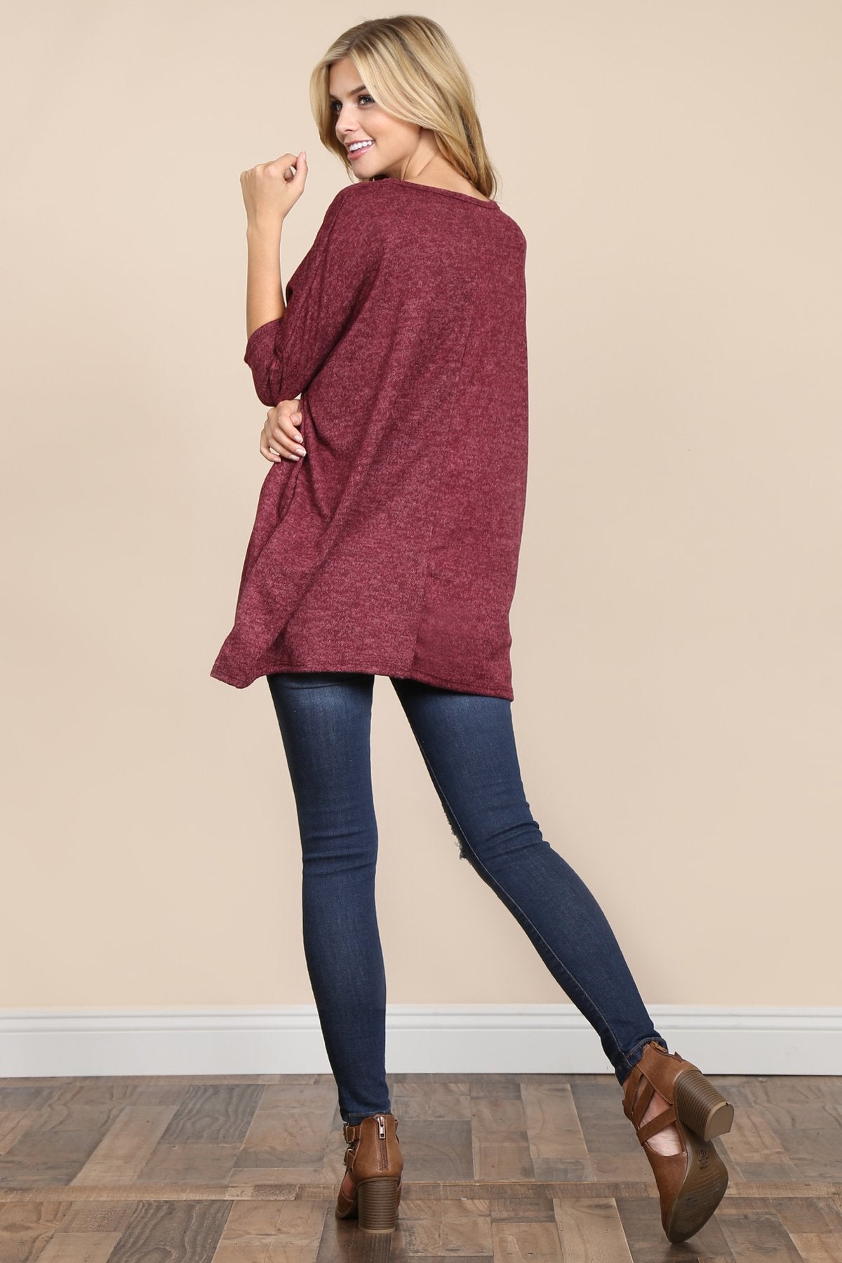 A woman stands against a beige background, wearing Riah Fashions Two Tone Hacci Oversized Dropped Shoulder Pocket Tunic in mustard, with hands in pockets and paired with ripped jeans.