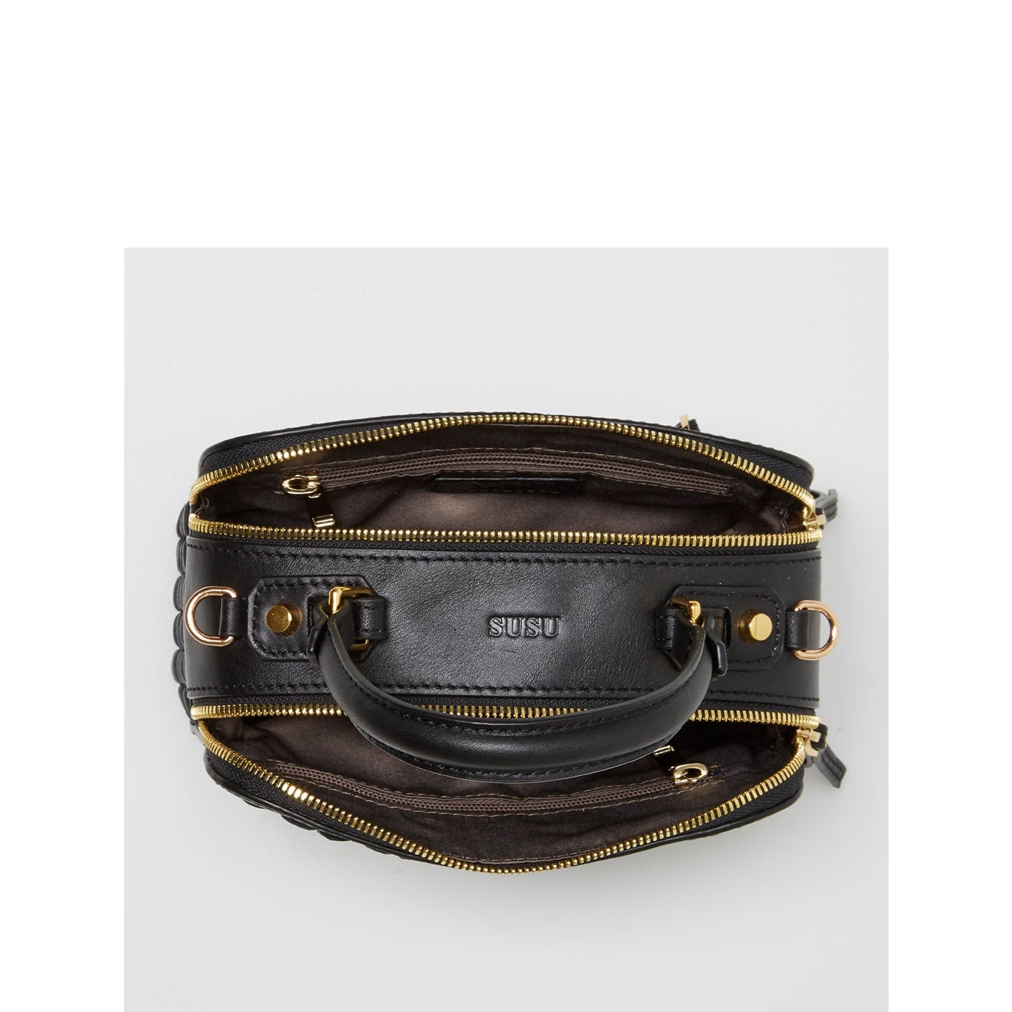 The SUSU Kayla Woven Leather Bag in black features a woven pattern, gold hardware, a top handle, and an adjustable shoulder strap.