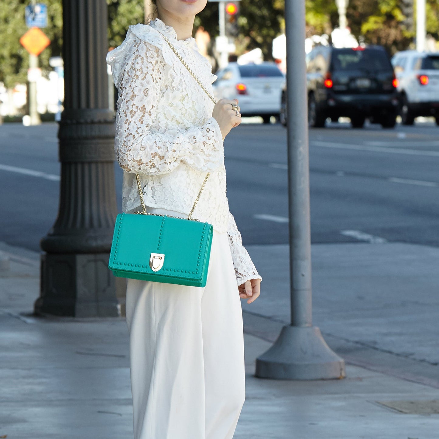 SUSU presents the Josie Green Leather Bag featuring a studded design and a gold chain strap.