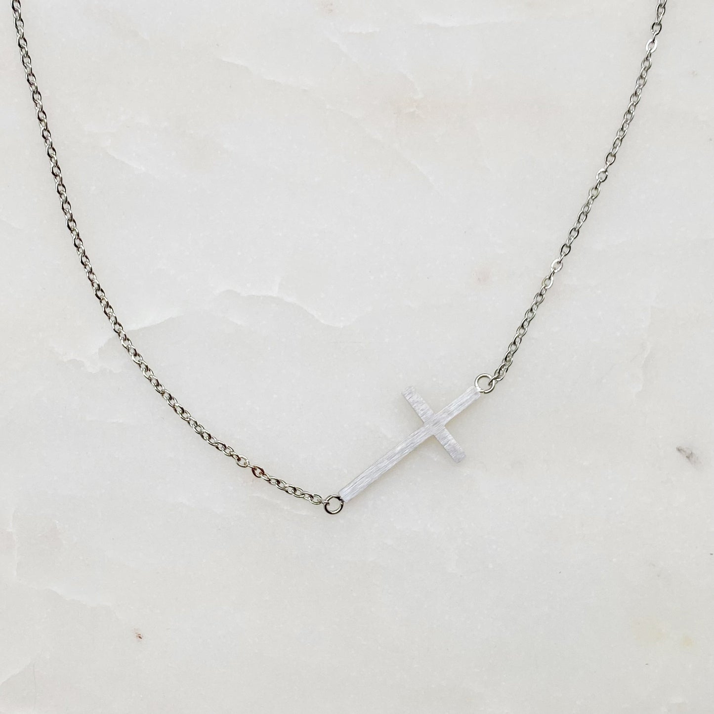 Two Kayla Cross Necklaces from Ellison + Young, one silver and one gold, presented on a white surface.