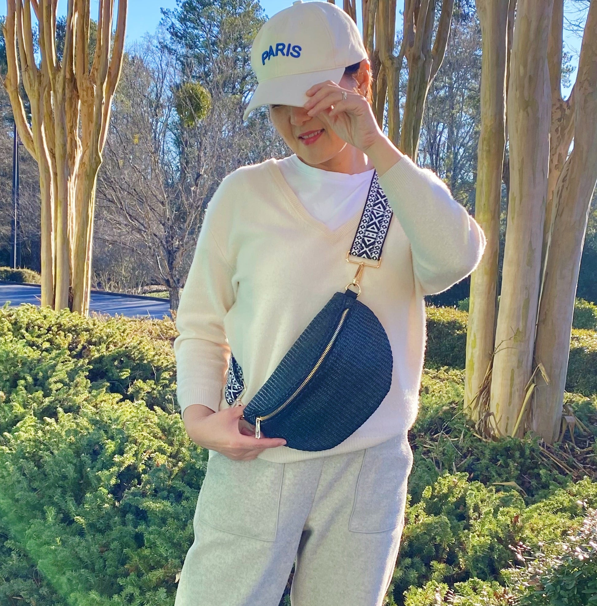 Four Bahama Breeze Fit All Sling Bags by Ellison + Young in pink, black, beige, and green with unique patterned straps are displayed on a white surface.