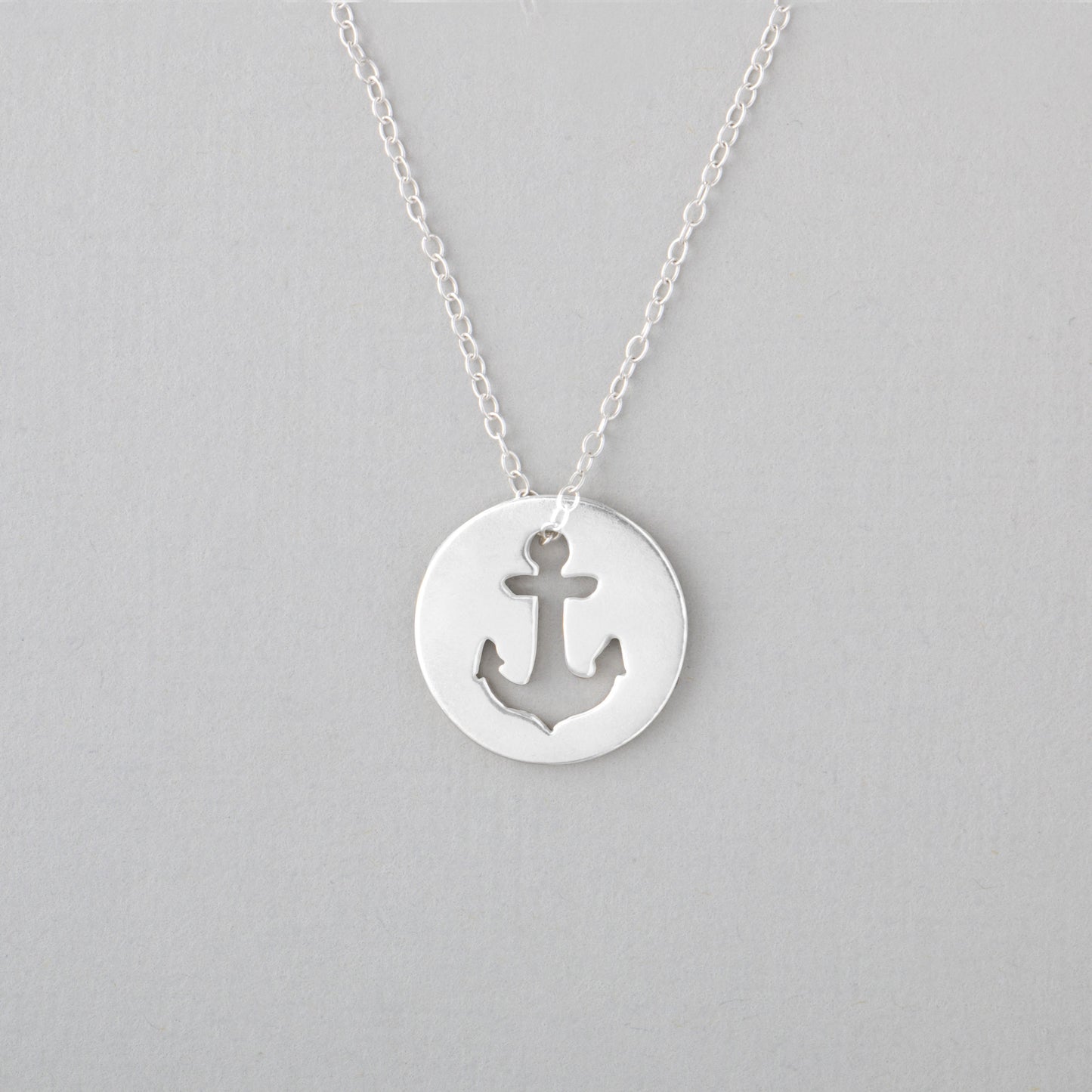 Sincerely Silvers Anchor Necklace is a sterling silver piece showcasing a circular pendant with a cut-out anchor design.