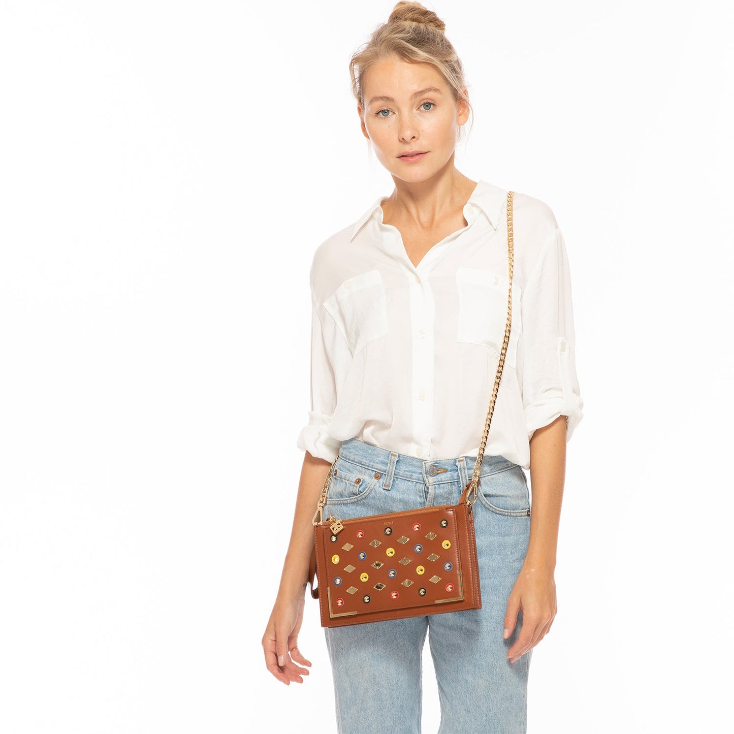 Brown Studded Crossbody Clutch by SUSU features colorful circular and diamond-shaped studs, a gold chain strap, and a zip closure.