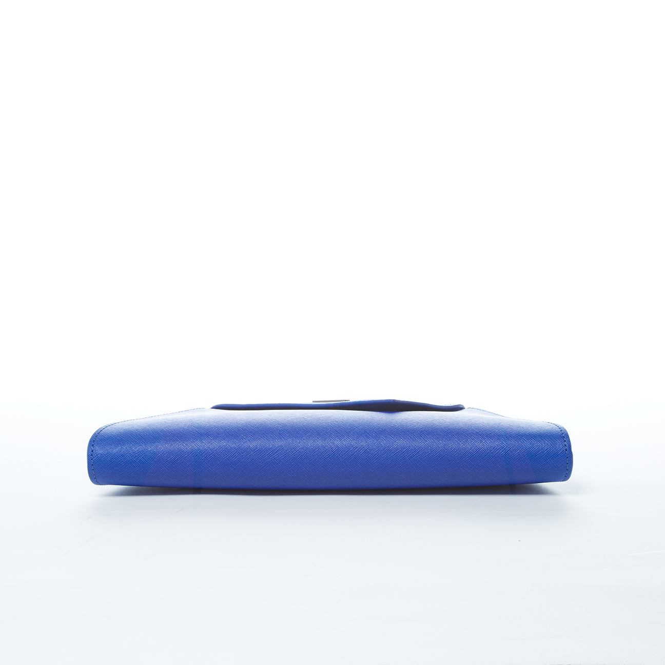A SUSU Angelica Cobalt Blue Leather Clutch Bag featuring a triangular flap design and a silver chain strap.