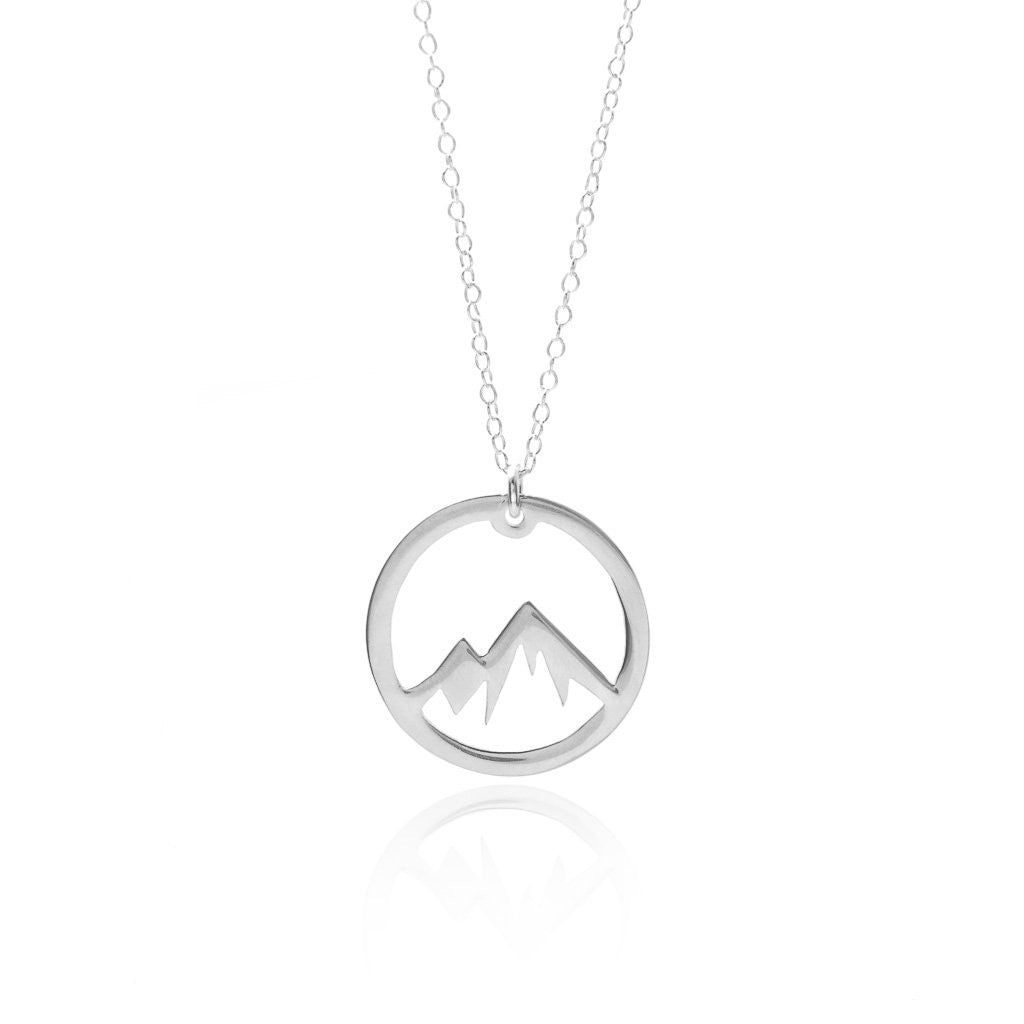 A person wearing a beige sleeveless top accessorized with the Silver Mountain Necklace by Sincerely Silver.