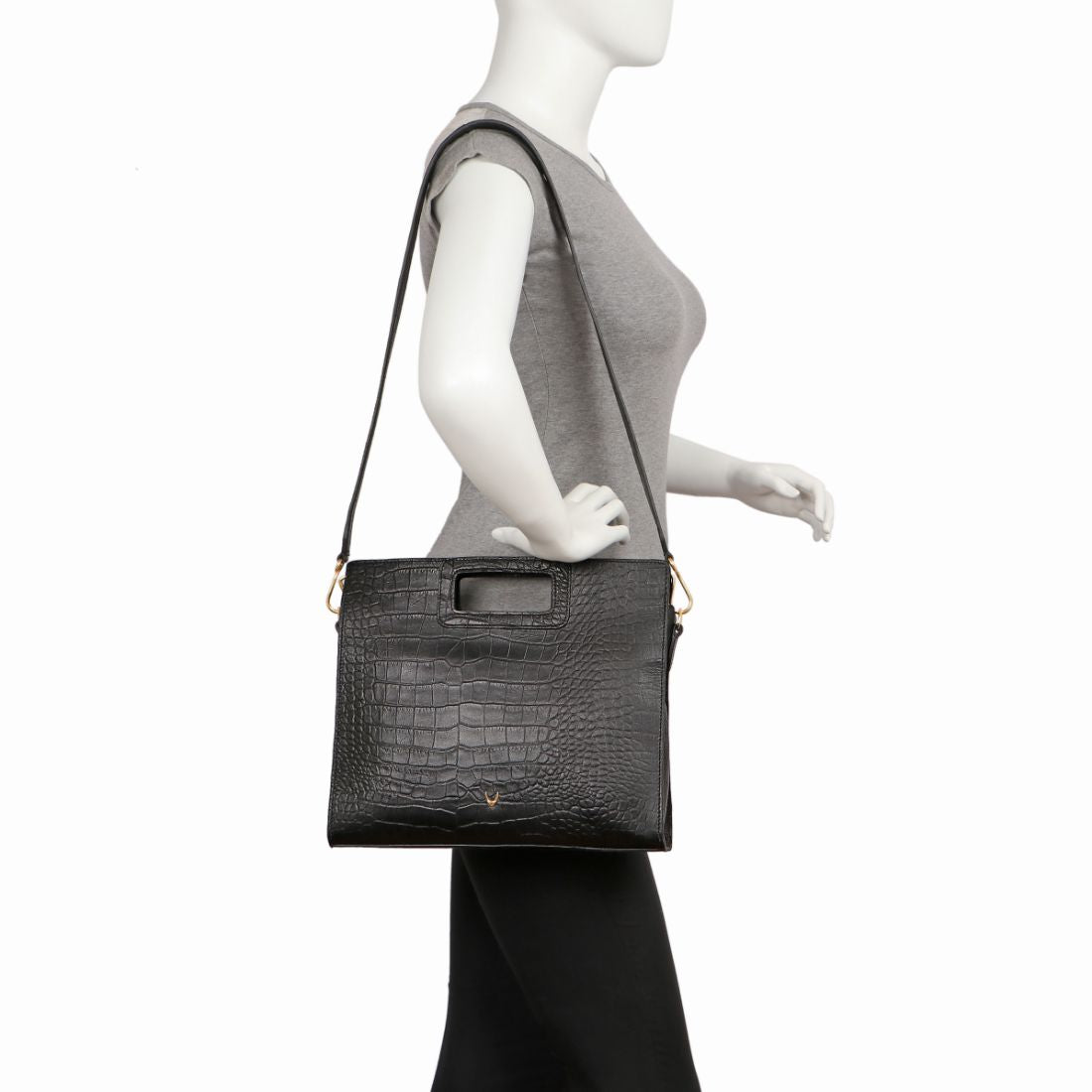 A Hidesign leather handbag in black features a textured design, rectangular cutout handle, and detachable shoulder strap.