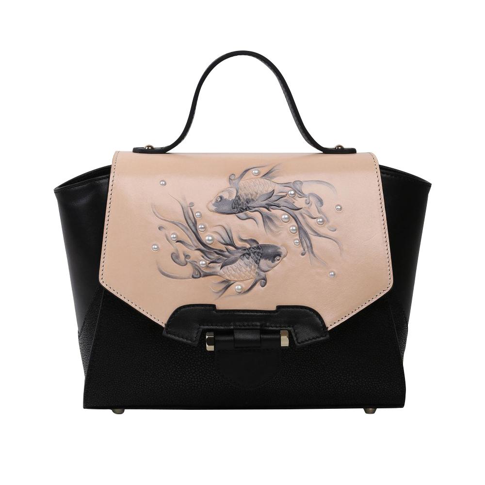 The Koi Small Black Satchel by Bellorita is a handbag with a black body, a tan flap adorned with fish designs, and decorative pearls.