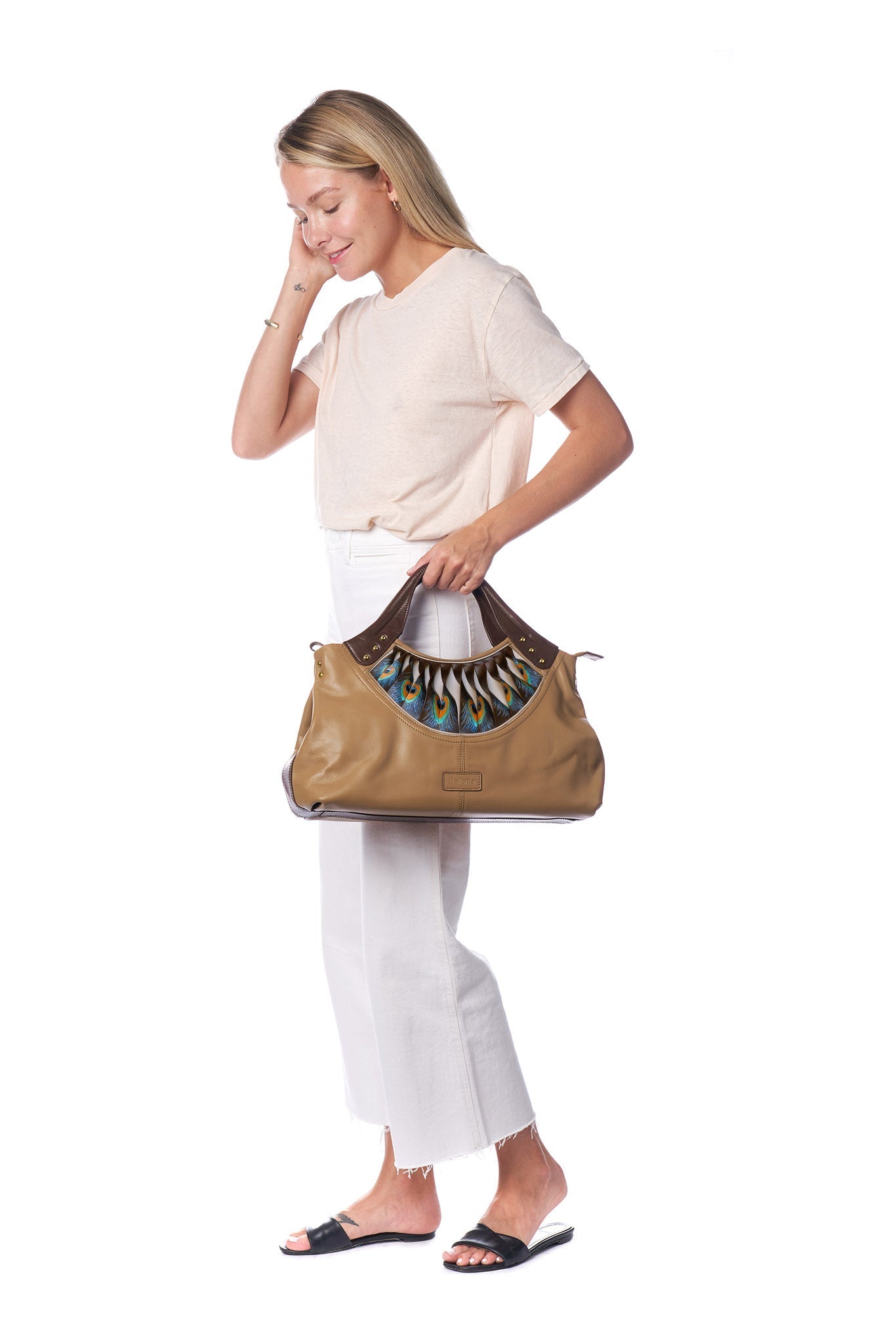 The Feather Brown Tote by Bellorita is a tan leather handbag with brown handles, showcasing a peacock feather design near the opening.