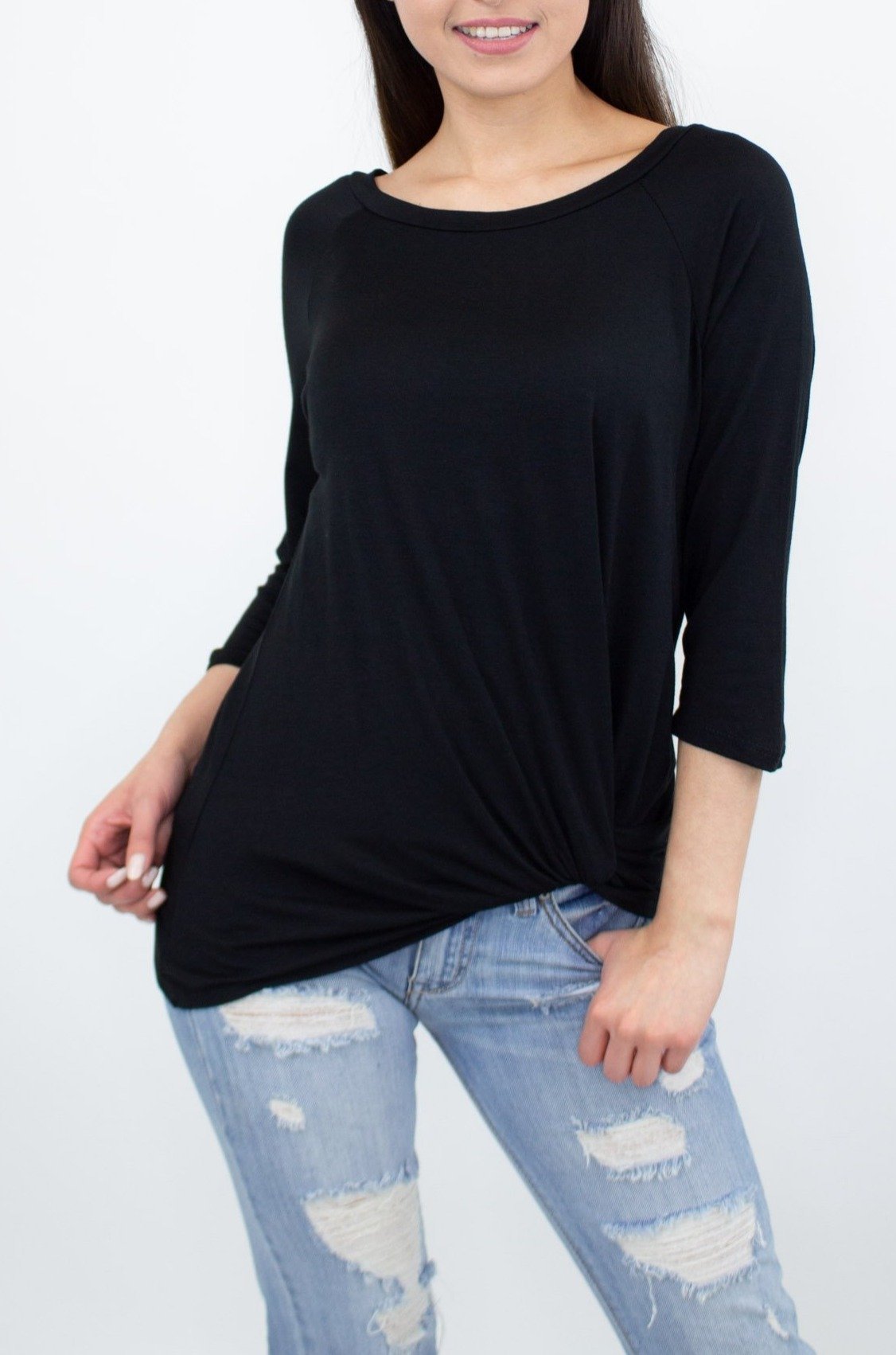 A person wearing the Stylespect Twisted Front Comfortable Top in black and ripped jeans stands against a plain background.