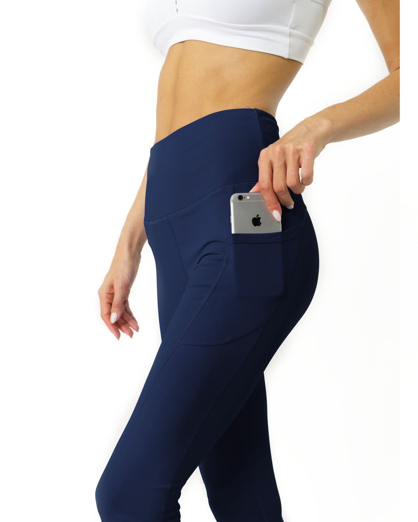 A person wearing Savoy Actives High Waisted Yoga Leggings in Navy Blue and black shoes stands against a white background.