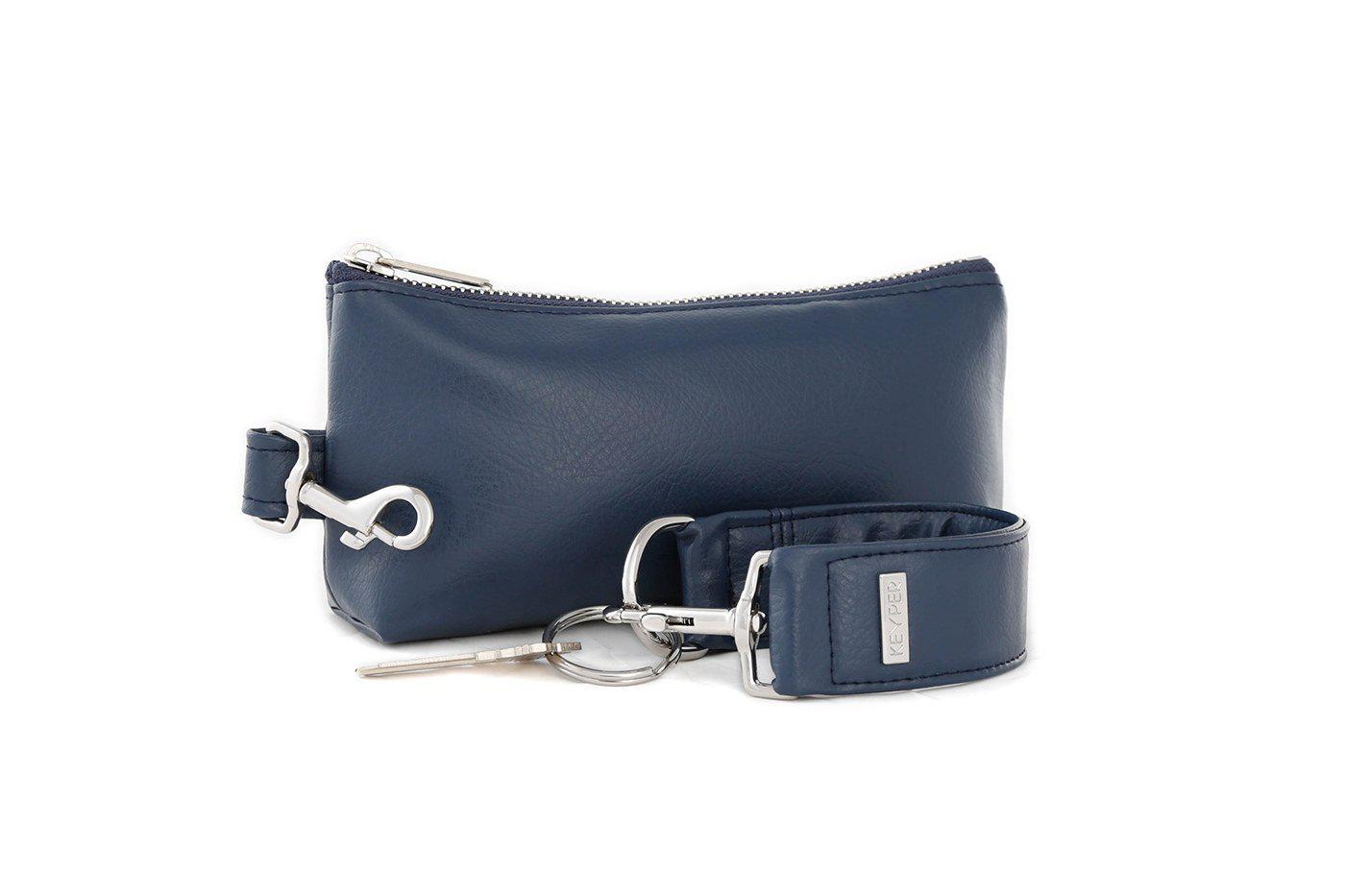 A compact True Navy vegan leather bag by KEYPER, with a gold zipper and clasp, comes with a detachable strap and includes a silver key attached to a key ring. Part of the 2-piece wristlet set.