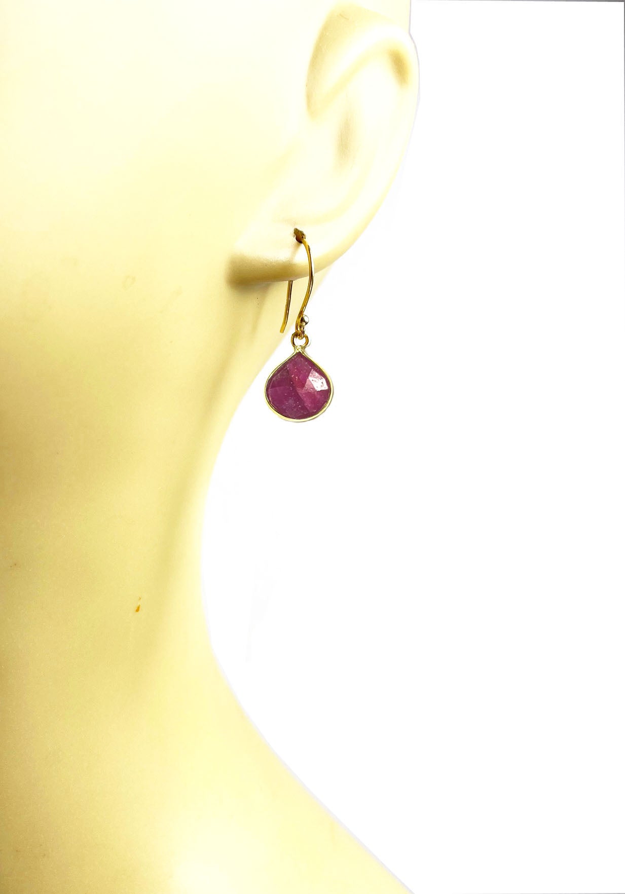 Gena Myints Ruby Bezel Drop Earrings feature gold hook settings with teardrop-shaped pink stones.