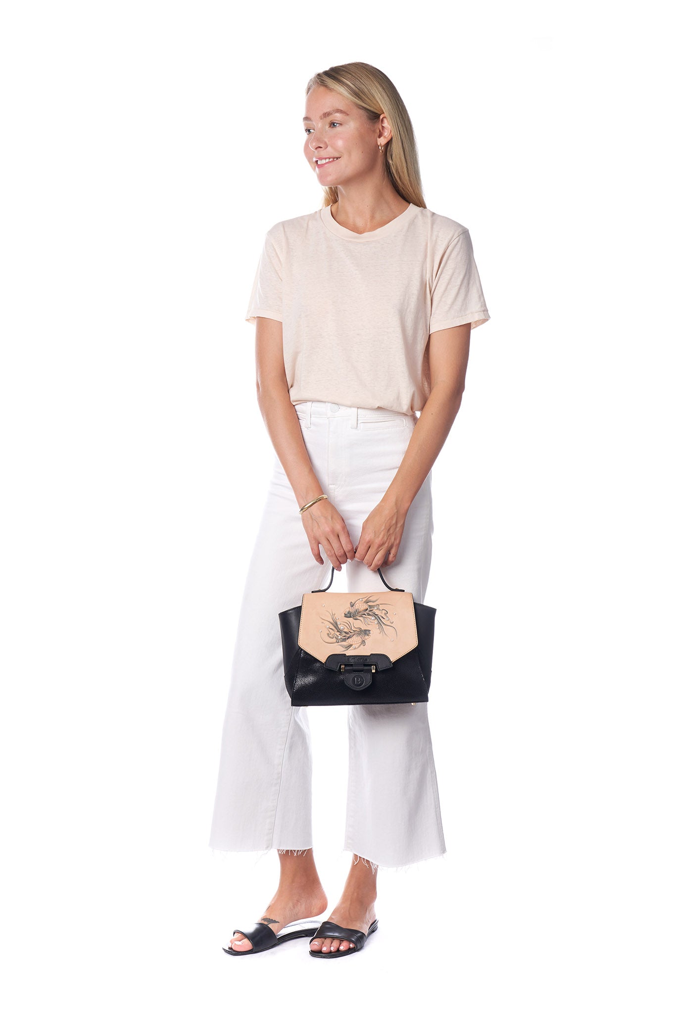 The Koi Small Black Satchel by Bellorita is a handbag with a black body, a tan flap adorned with fish designs, and decorative pearls.