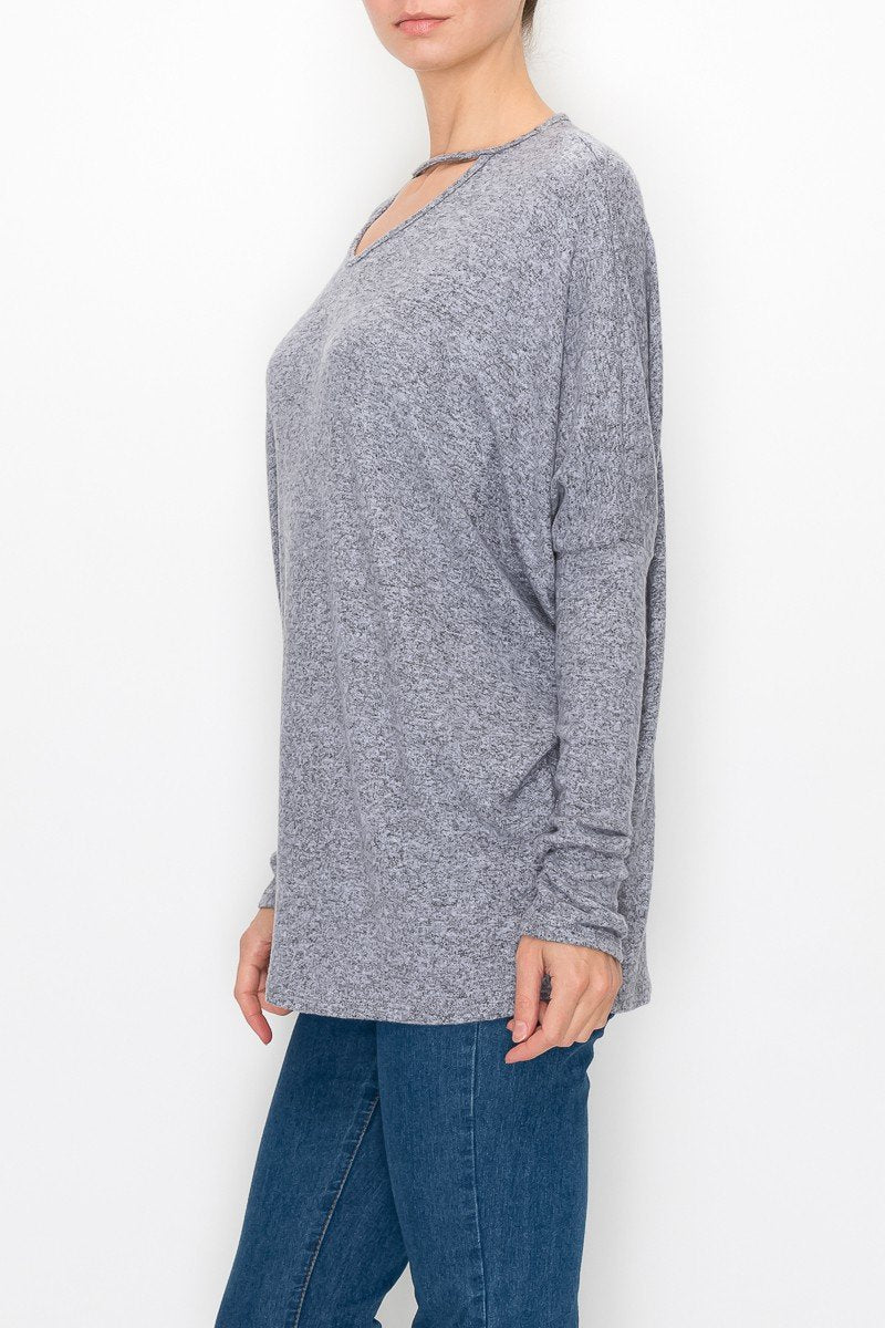 A person is wearing the Stylespect Cutout Front Long Sleeve Top in grey paired with blue jeans.