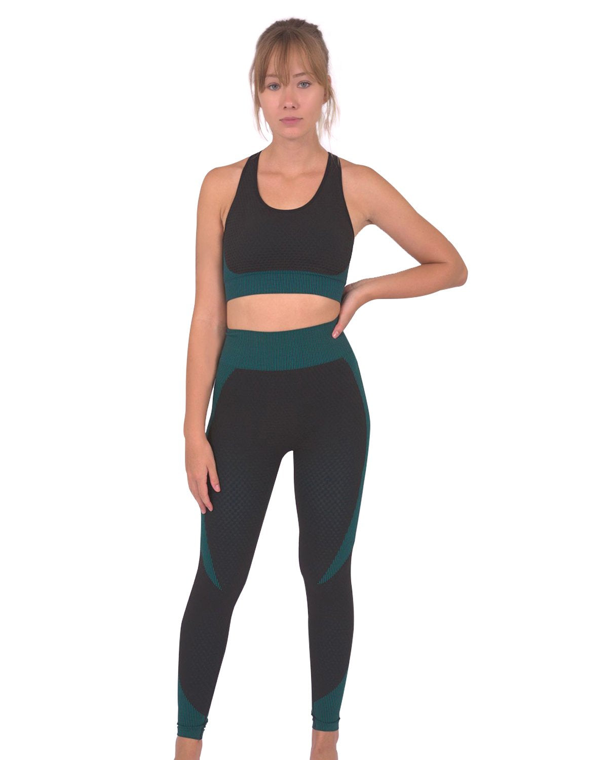 A person wearing Savoy Actives Trois Seamless Legging in Black with Teal Blue and black sneakers stands against a gray textured wall.