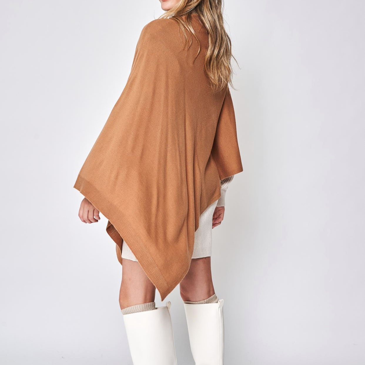 Someone wearing the Take With Me Travel Poncho by Ellison + Young with plaid pants against a plain white background.