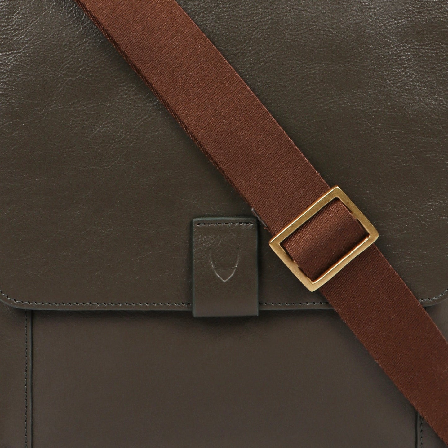 Hidesigns Aiden Genuine Leather Medium Crossbody is a dark brown shoulder bag featuring a wide strap and rectangular brass buckle.