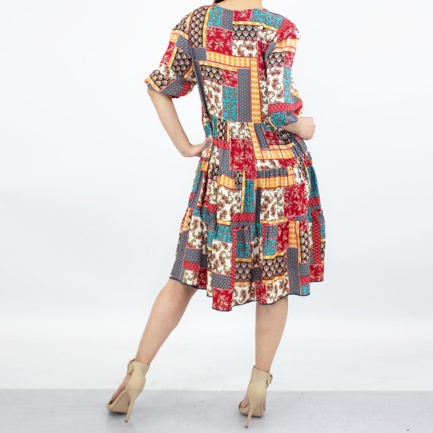 A person wearing the Stylespect Flare Bottom 3/4 Sleeve Dress in Red and beige high heels, standing against a plain background.