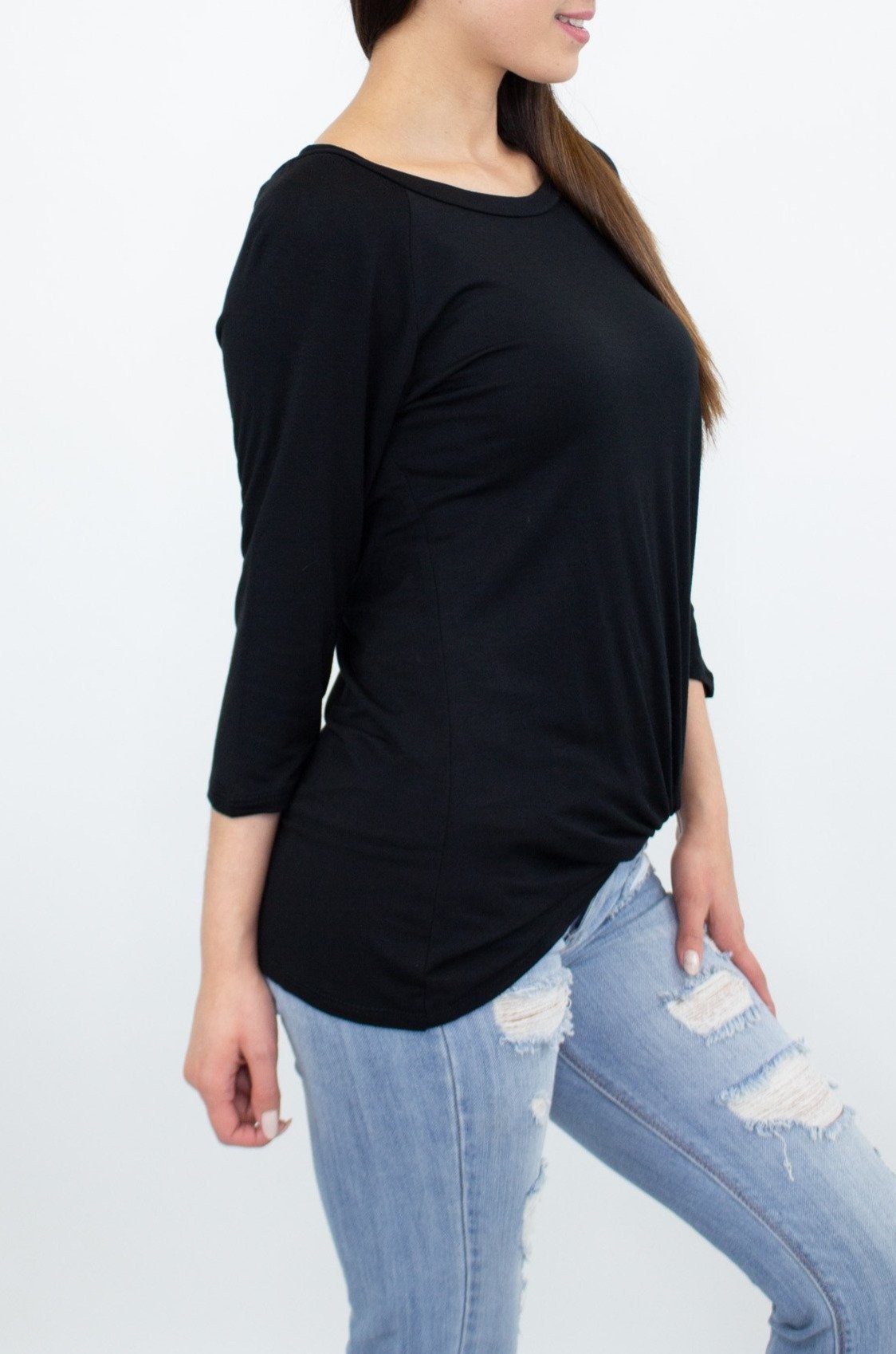 A person wearing the Stylespect Twisted Front Comfortable Top in black and ripped jeans stands against a plain background.