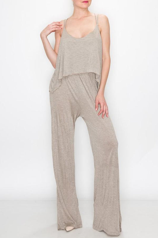 A person models the Stylespect Layered Jumpsuit in khaki, featuring a light gray, sleeveless, loose-fitting design, against a plain white backdrop.