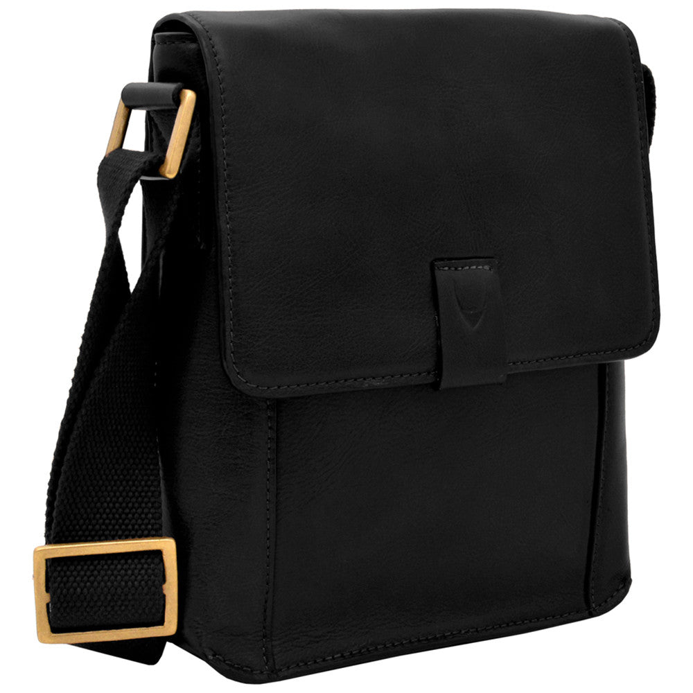 The Aiden Genuine Leather Mini Crossbody by Hidesign is a brown leather shoulder bag featuring a flap cover and an adjustable fabric strap with a brass buckle.