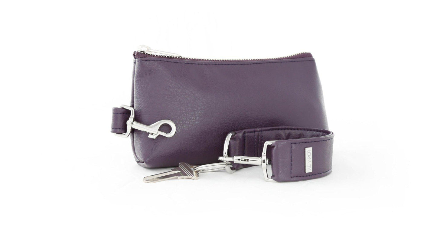 The Pretty Purple Vegan Leather 2-Piece WRISTLET SET by KEYPER features a wristlet with a zipper and gold accents, plus a detachable strap, and comes next to keys on a silver keyring.