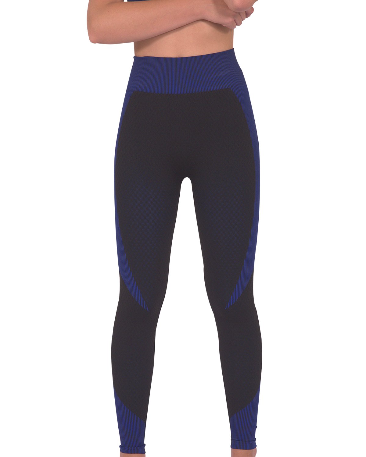 Someone wearing Savoy Actives Trois Seamless Legging in Black with Navy stands on a brown couch in a modern room with plants.