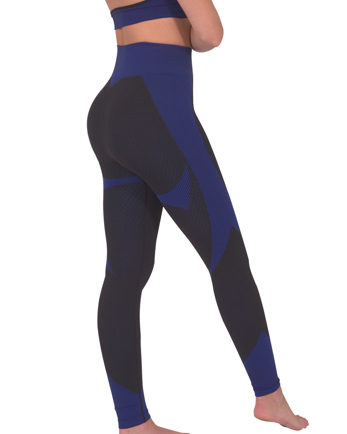 Someone wearing Savoy Actives Trois Seamless Legging in Black with Navy stands on a brown couch in a modern room with plants.