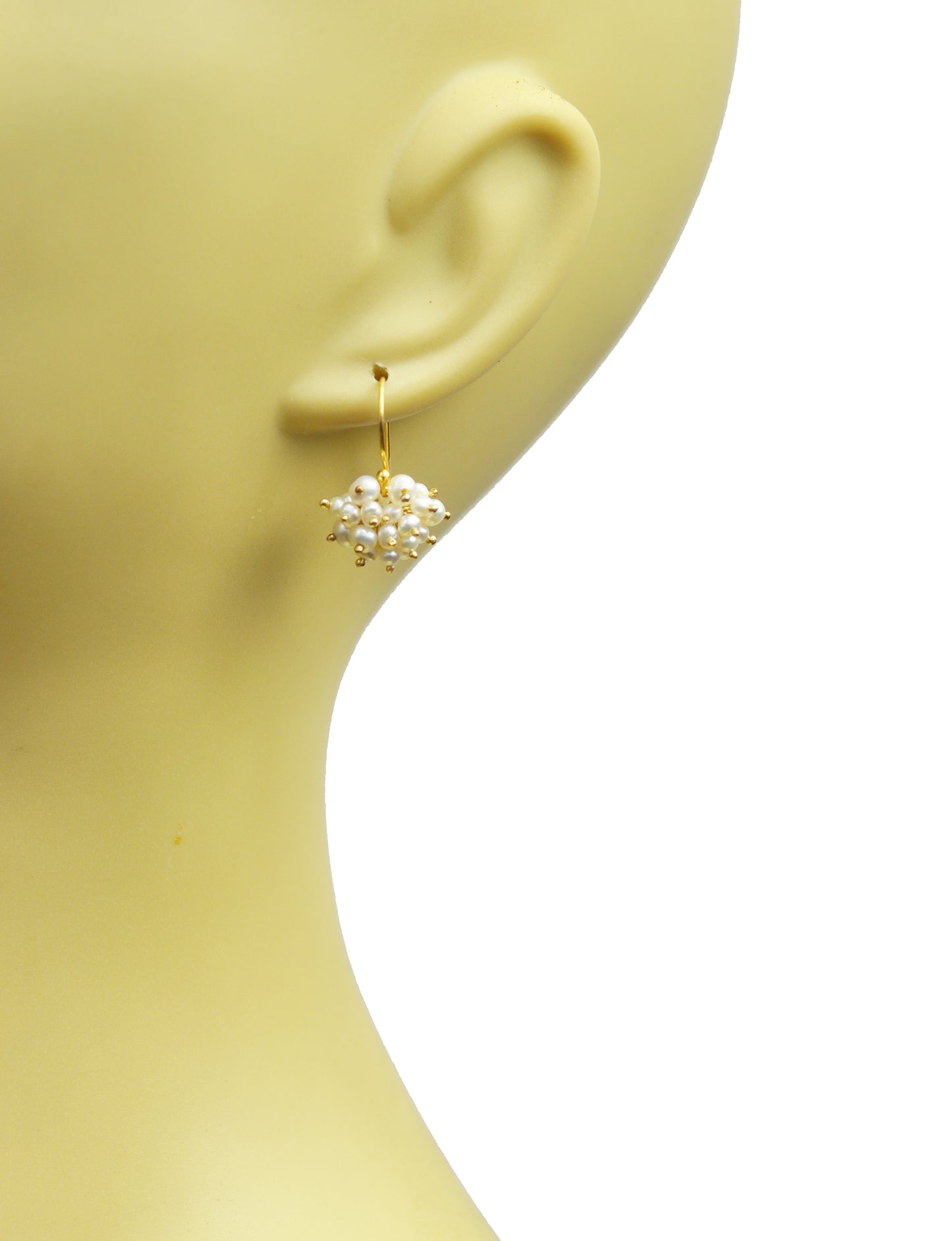 A mannequin head displays the Gena Myint Pearl Cluster Vermeil Earrings, featuring gold hoops adorned with multiple small white pearls.